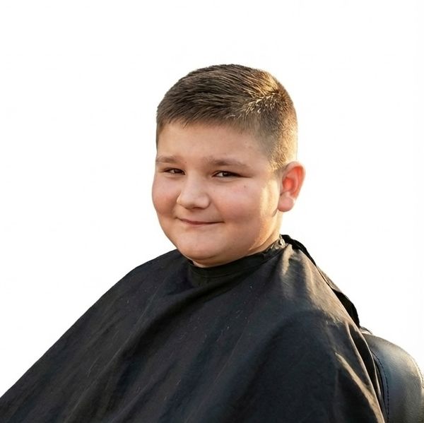 Happy child after a first-chair kids' cut at Dynamic Stylz Salon